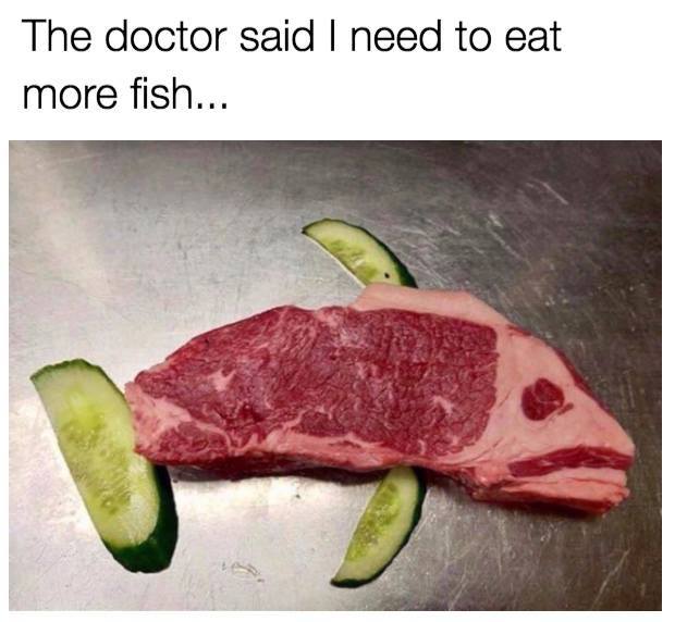 A steak in the shape of a fish, with pickles as dorsal fin, pelvic fin and tail fin